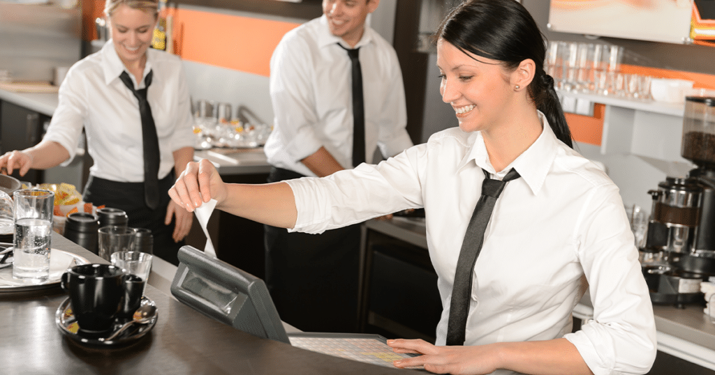 A restaurant worker sliding card at a pos terminal.